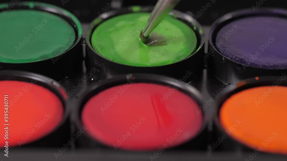 artist painter mixing green oil paint with brush on palette 4k