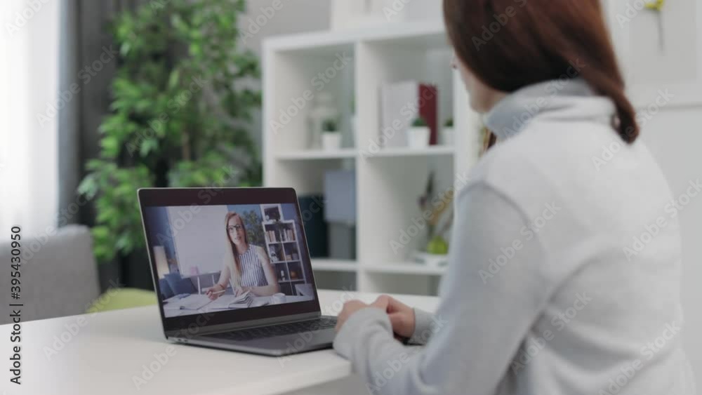 Mature lady in casual clothing sitting at home and having video chat on laptop. Concept of people, remote work and modern technology. Mature lady in casual clothing sitting at home and having video chat on laptop. Concept of people, remote work and modern technology.