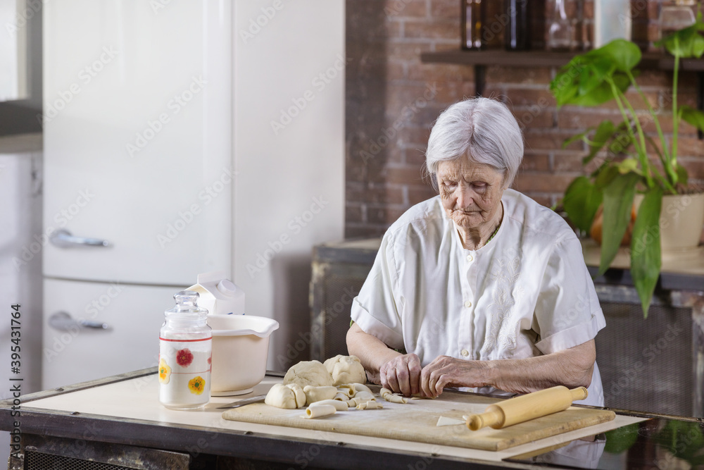 Senior woman preparing pastries in the kitchen at home Senior woman preparing pastries in the kitchen at home