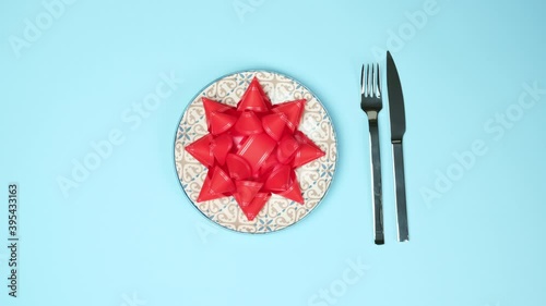 round white plate and metal fork and knife on a blue background, top view, festive table setting