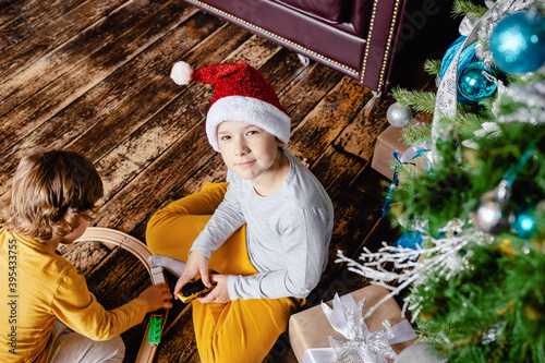 Fototapeta Naklejka Na Ścianę i Meble -  Kids with Xmas gifts under Christmas tree