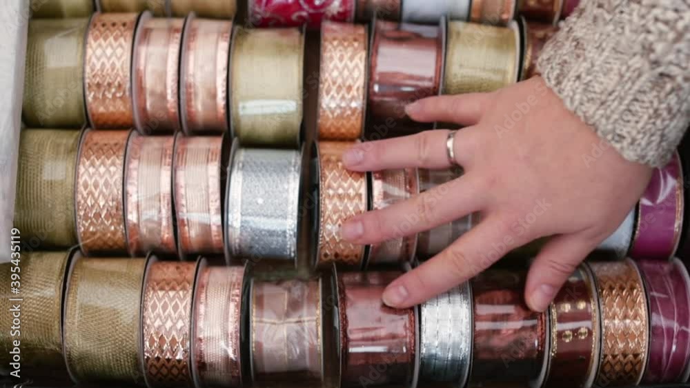 A hands touches a set of colored ribbons, symbolizing the difficulty of choosing from a variety in the craft shop. Sewing lover gift selection for the very best in handmade pieces. A hands touches a set of colored ribbons, symbolizing the difficulty of choosing from a variety in the craft shop. Sewing lover gift selection for the very best in handmade pieces.