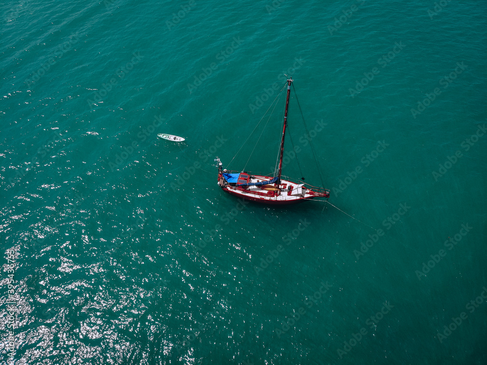 Fototapeta premium Aerial view of a sailing yacht in the turquoise water of the Andaman sea. Phuket. Thailand