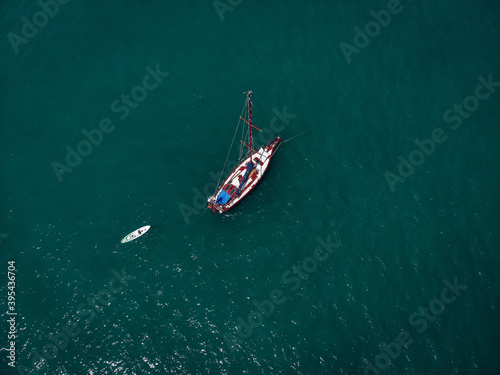 Aerial view of a  sailing yacht  with white kayak in the turquoise water of the Andaman sea. Phuket. Thailand © Semachkovsky 