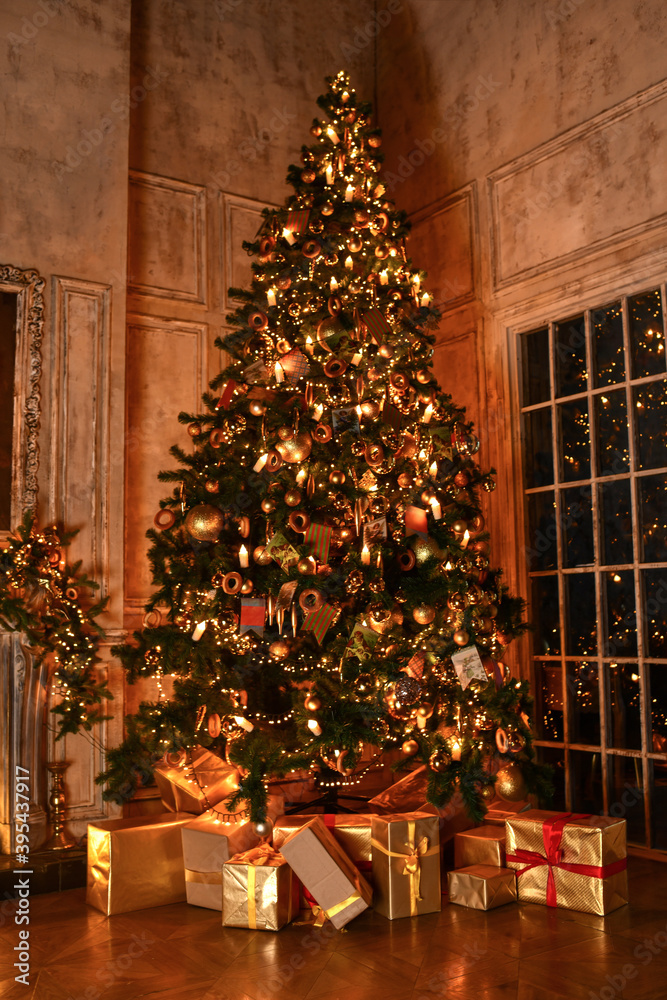 Christmas, New Year interior with loft design studio decorated fir tree with garlands, balls and gift present boxes at evening dinner