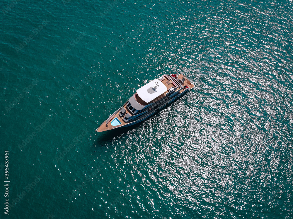 Aerial picture of an isolated yacht with brown wooden design in the sea Aerial picture of an isolated yacht with brown wooden design in the sea