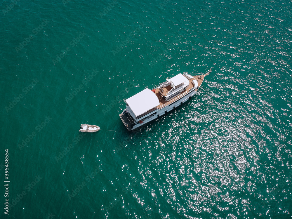Aerial drone top view photo of luxury yacht with white rubber boat. Phuket. Thailand.. Aerial drone top view photo of luxury yacht with white rubber boat. Phuket. Thailand..