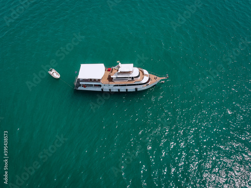 Aerial drone top view photo of luxury yacht with white rubber boat. Phuket. Thailand..