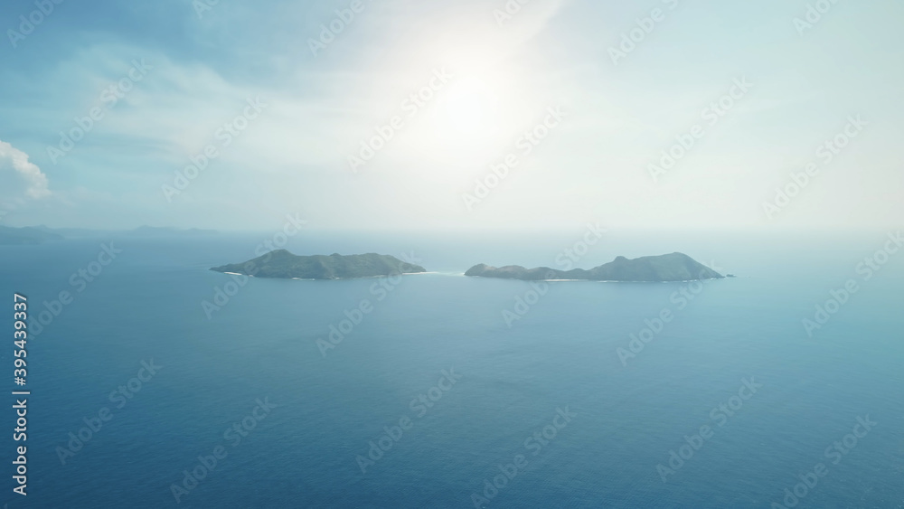 Aerial ocean seascape with sun shine at blue sky. Small tropical islands on water surface. Serene sea bay scenery at sunlight. Amazing summer nobody nature scape at soft light. Birds-eye drone shot Aerial ocean seascape with sun shine at blue sky. Small tropical islands on water surface. Serene sea bay scenery at sunlight. Amazing summer nobody nature scape at soft light. Birds-eye drone shot