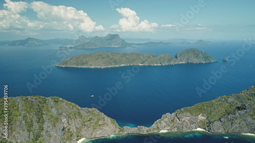 Hilly island at sea bay aerial shot. Epic landscape of green forest trees at mountain isles with serene seascape. Wonderful summer nature scenery of Palawan island, Philippines, Visayas Archipelago