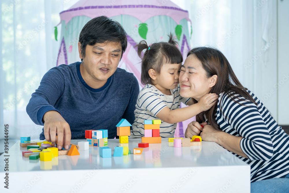 Happy Family, Little girl playing Developmental toy. little girl play brick toy and kiss her mom in home sweet home. Happy Family, Little girl playing Developmental toy. little girl play brick toy and kiss her mom in home sweet home.