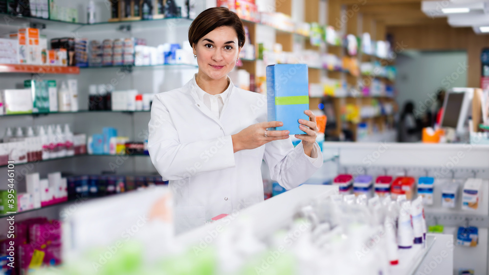 Cheerful positive female pharmacist suggesting useful body care products in pharmacy