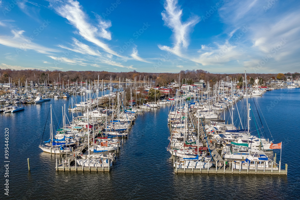 Fototapeta premium Scenic aerial panorama of Deale waterfront docks on the Western Shore of Chesapeake Bay Maryland, dozens of luxury sailboats docking in the marina. 