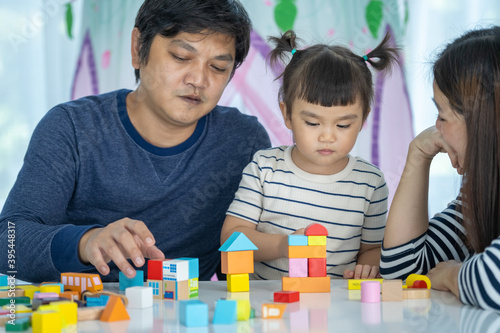 Happy Family ,Parents play Developmental toys with their little girl in home sweet home.