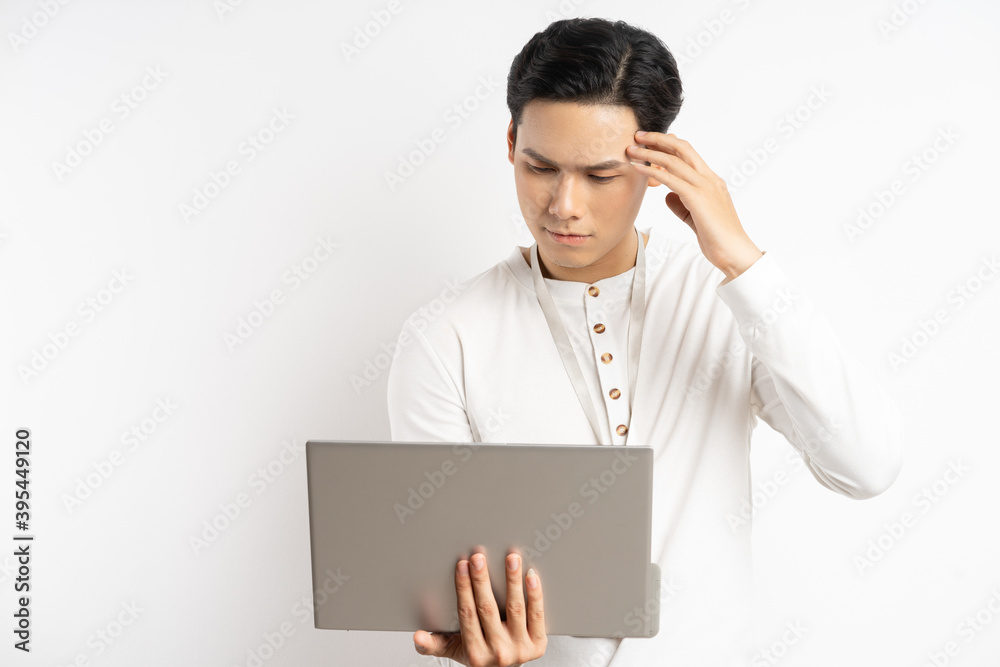 Asian businessman holding his head while using the computer Asian businessman holding his head while using the computer