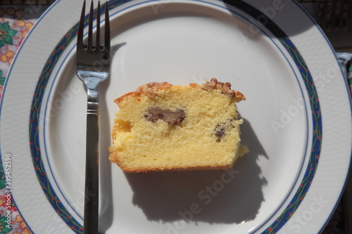 View of homemade orange walnut cake with fork under sunlight in plate on table  in Vancouver, British Columbia, Canada.