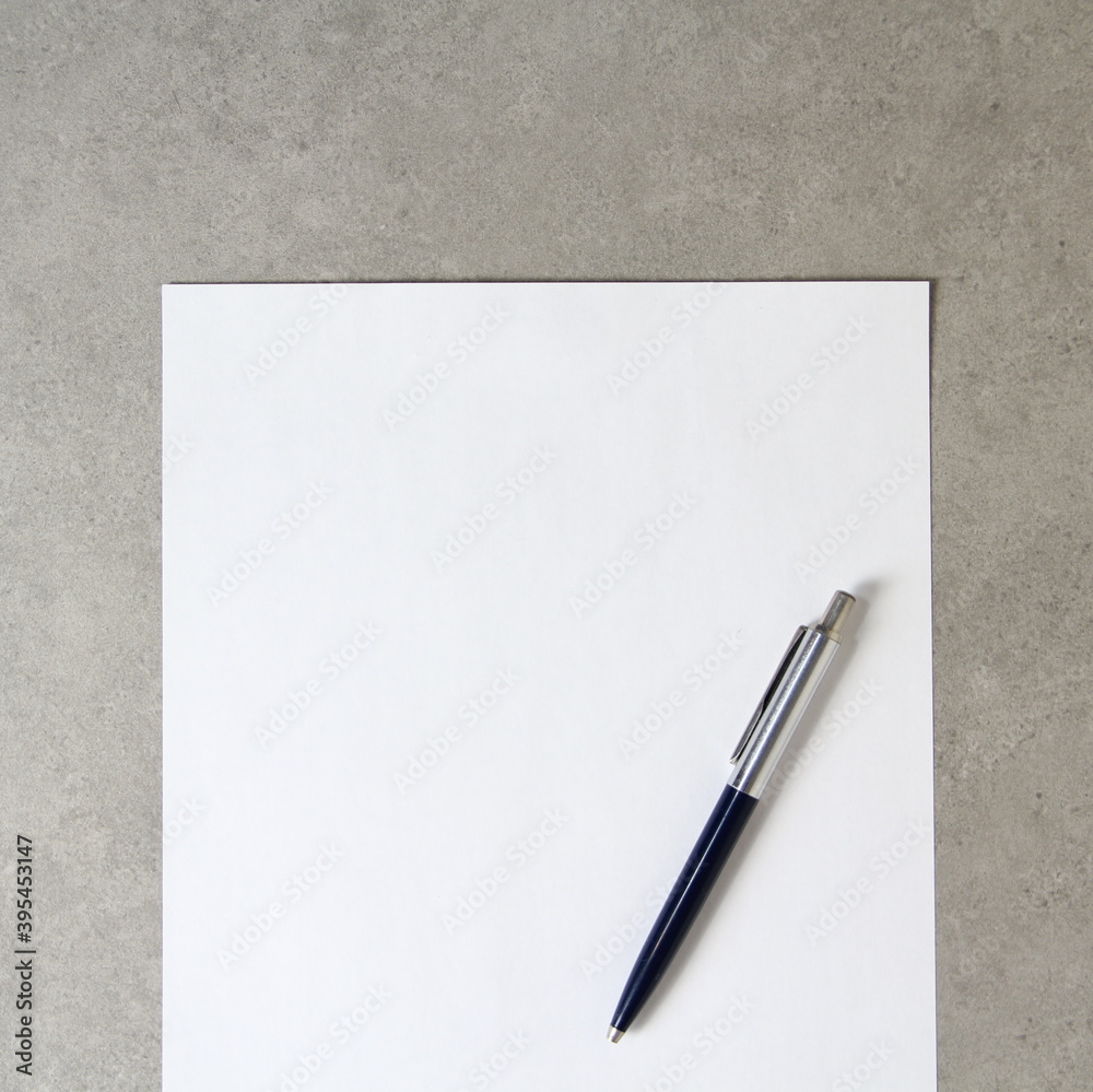 Template of white paper with a ballpoint pen on light grey concrete background. Concept of new idea, business plan and strategy, empty space for text Template of white paper with a ballpoint pen on light grey concrete background. Concept of new idea, business plan and strategy, empty space for text
