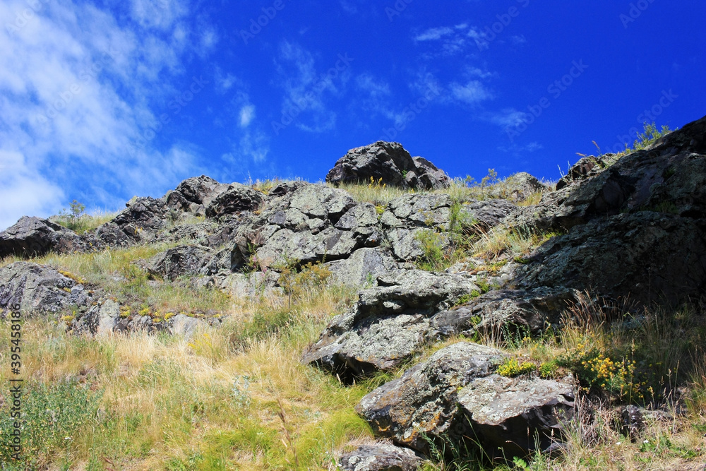 Stone granite rock on a background of blue sky Stone granite rock on a background of blue sky