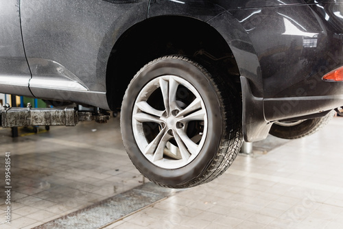 Front wheels of modern car raised in workshop for maintenance, stock image © LIGHTFIELD STUDIOS