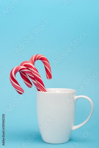 candy canes in white mug on blue 