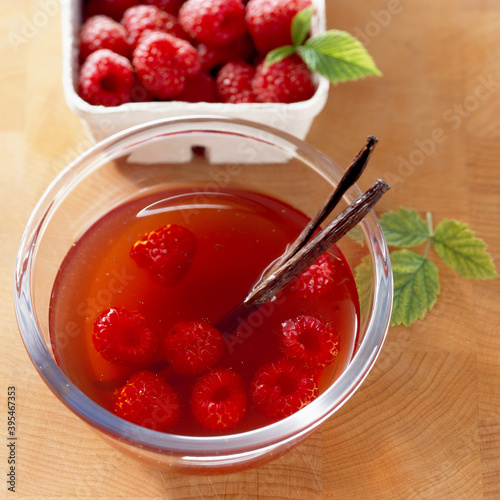 Homemade raspberry vinegar with vanilla and fresh berries photo