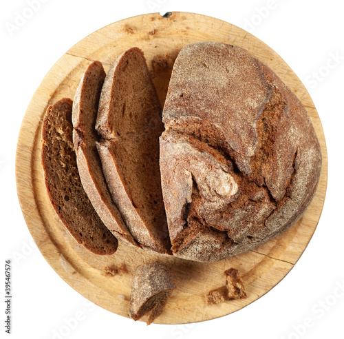 Freshly baked sliced brown bread on cutting board isolated on white background. Flat lay.
