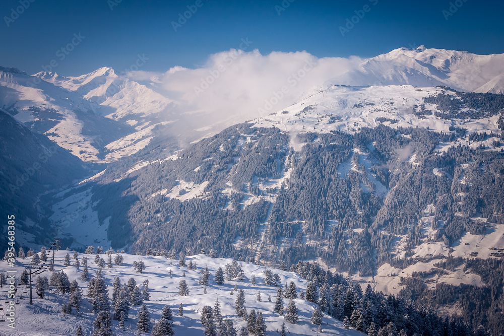 Winter landscape in the Alps. Frosty sunny day. Spruce covered with snow and frost on the background of the mountains. Ski resort Mayrhofen, Austria. Zillertal valley