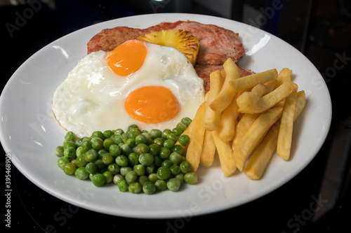 Slika na platnu Grilled horseshoe gammon steak with grilled pineapple, 2 fried eggs, peas and Fr
