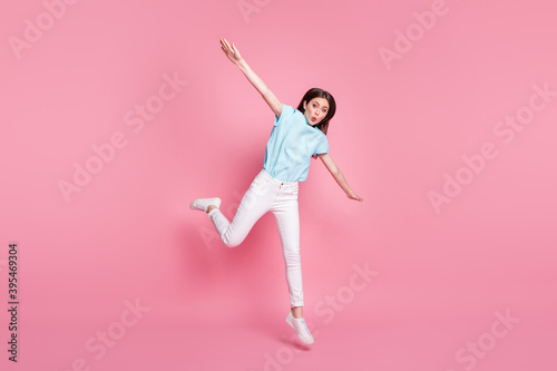 Full body photo of astonished girl jump hold hands wear white gumshoes isolated over pink color background