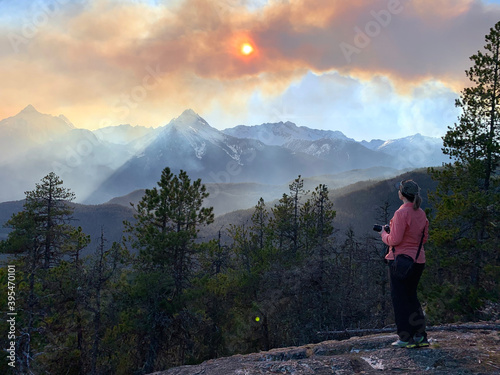 Wildfire in mountains. Woman watching  forest fire near Vancouver. British Columbia. Canada. 