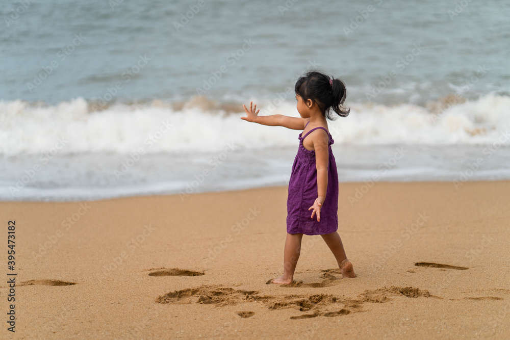 Cute little girl playing on the beach in morning. Cute little girl playing on the beach in morning.