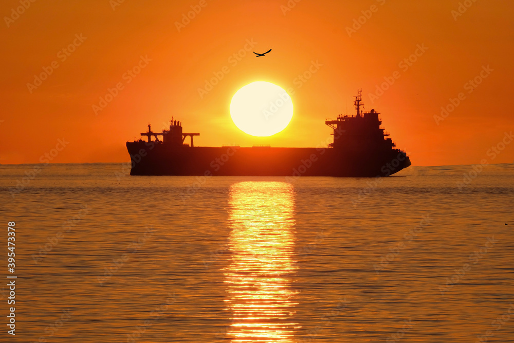 Low sun over the cargo ship in sunset. Port of Vancouver. British Columbia. Canada 