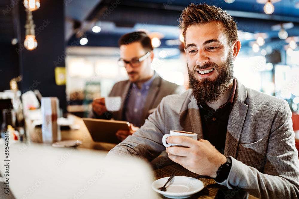 Cheerful businessmen using laptop at the meeting