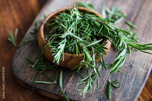Organic fresh rosemary herb on textile napkin on wooden table photo
