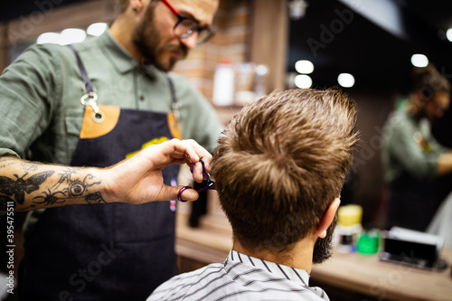 Man having a haircut with a hair clippers in barbershop salon