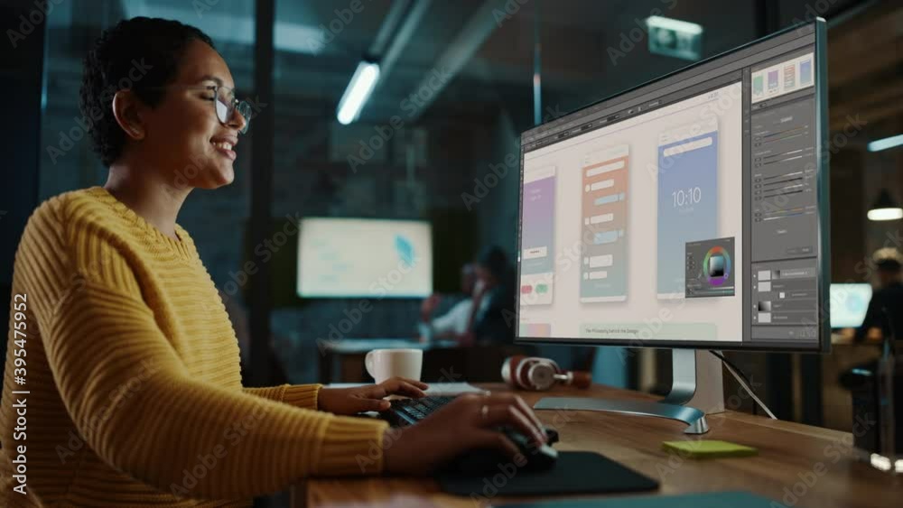 Young Latina Designer Working on a Desktop Computer in Creative Office. Beautiful Diverse Multiethnic Female is Developing a New App Design and User Interface in a Digital Graphics Editing Software.