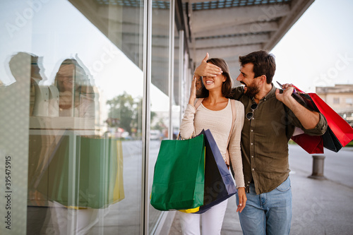 Couple of tourists walking in a city street and shopping, having fun