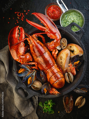 Cooked lobster, mussels and prawns with bread in a pot