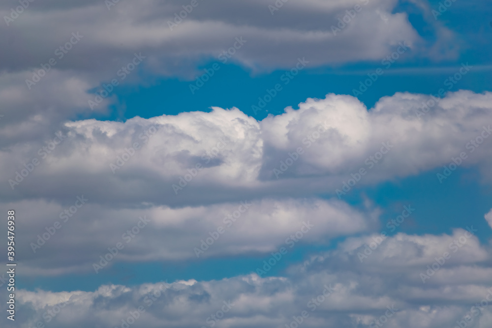 Obraz premium The blue sky is rich in color in clear weather with beautiful lush clouds. The beauty of nature in the fresh air, the layer of atmosphere visible to the eye from bottom to top