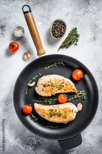 Turkey breast fillet in a frying pan. Grilled steak. White background. Top view