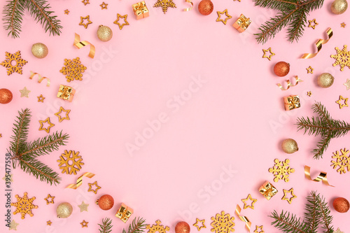 Circle frame made of Christmas decorations pattern on a pink background. Festive composition with copy space.
