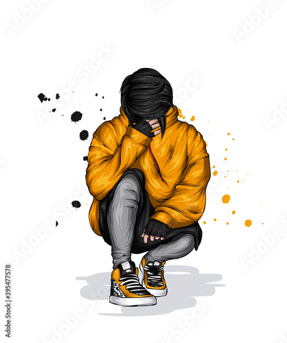 A guy in a stylish hoodie, shorts and sneakers is squatting. Clothes and accessories.
