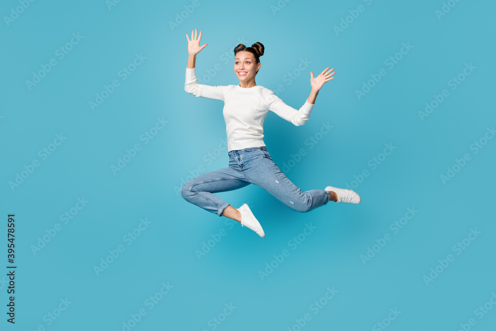 Full length photo of girl jump palms look far away wear white sweater jeans footwear isolated blue color background