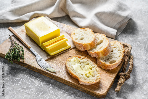 Farm butter and fresh baguette with butter. Gray background.Top view