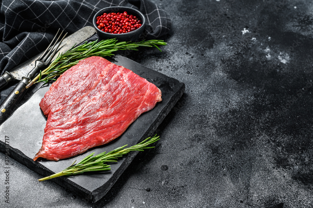 Flat iron steak. Raw Marble beef meat black Angus. Black background. Top view. Copy space