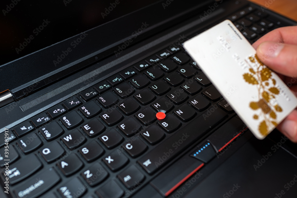 Closeup Hand Holding Credit Card near keyboard And Shopping Online Closeup Hand Holding Credit Card near keyboard And Shopping Online