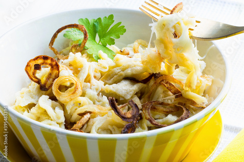 Cheese spaetzle (home-made noodles) with fried onions photo