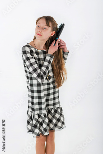 Closeup portrait girl brushing her hair on white