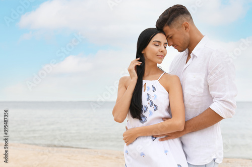 Lovely couple spending time together on beach. Space for text