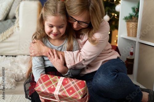 Close up of grandmother giving her granddaughter a Christmas gift © gpointstudio